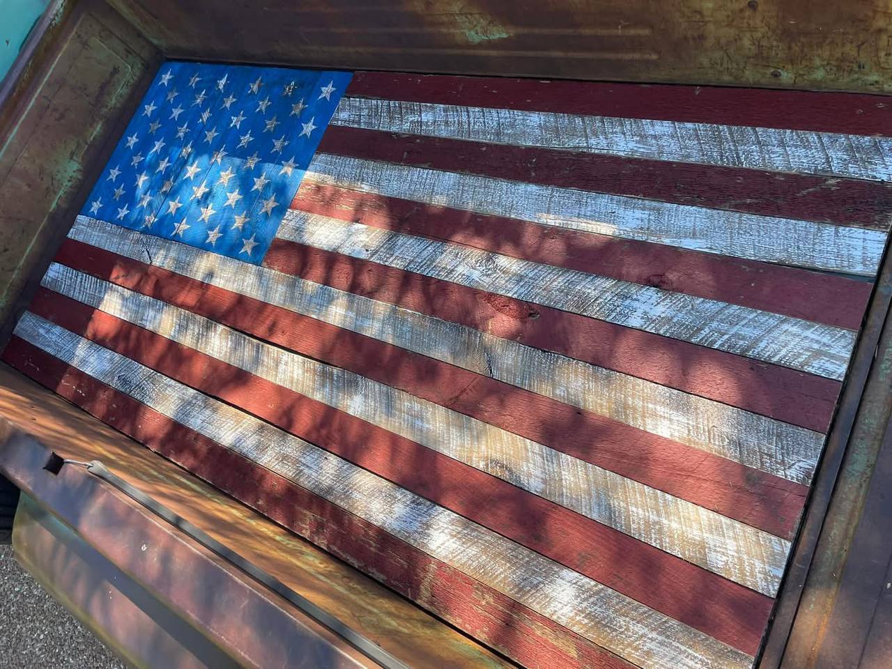 Close-up of barnwood American flag showing wood grain, patina, and hand-stained stripes
